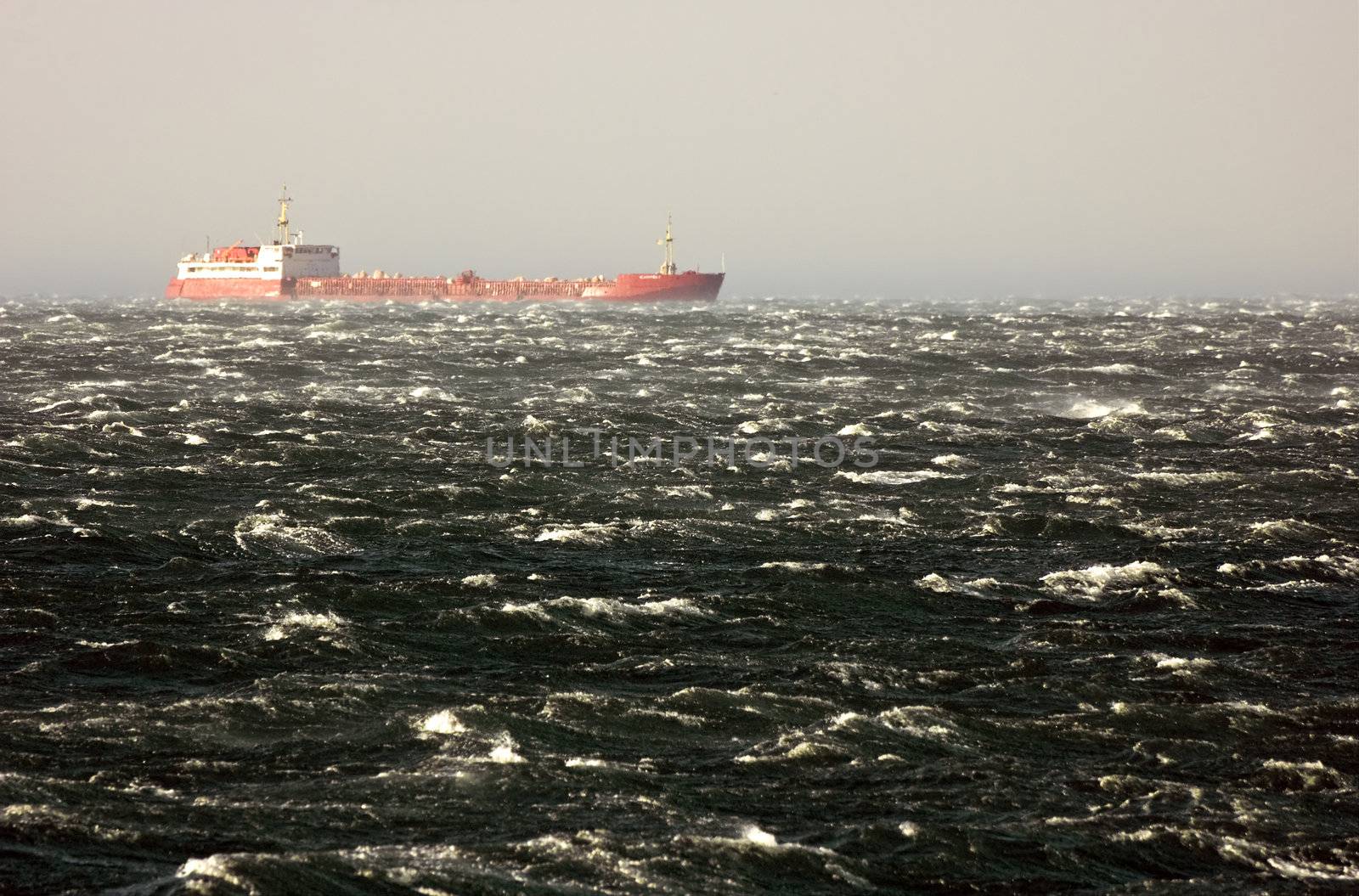 Merchant ship ploughing the waves of a rough sea