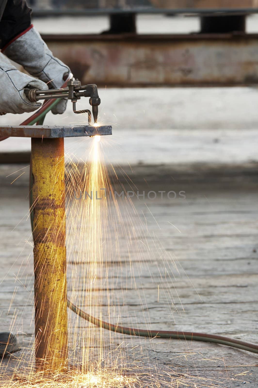 a welder working a torch at shipyard