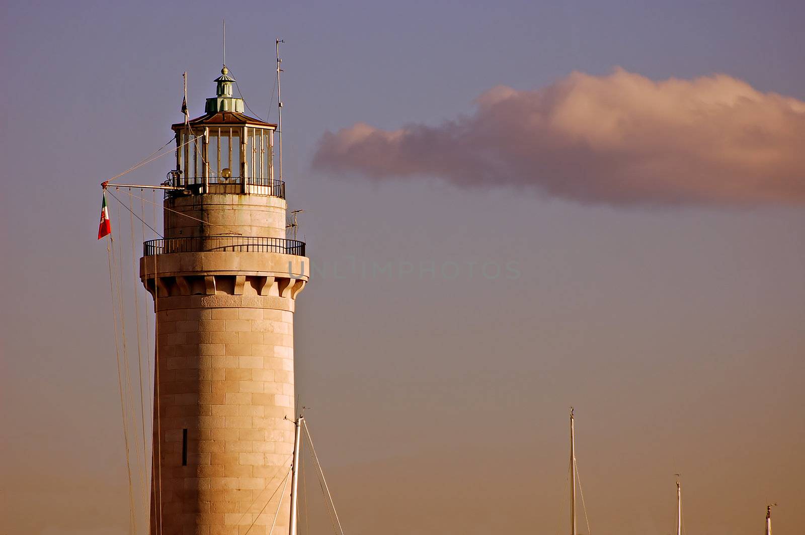 Lighthouse with a nice cloud in the sky illuminated by a dramatic sunset light