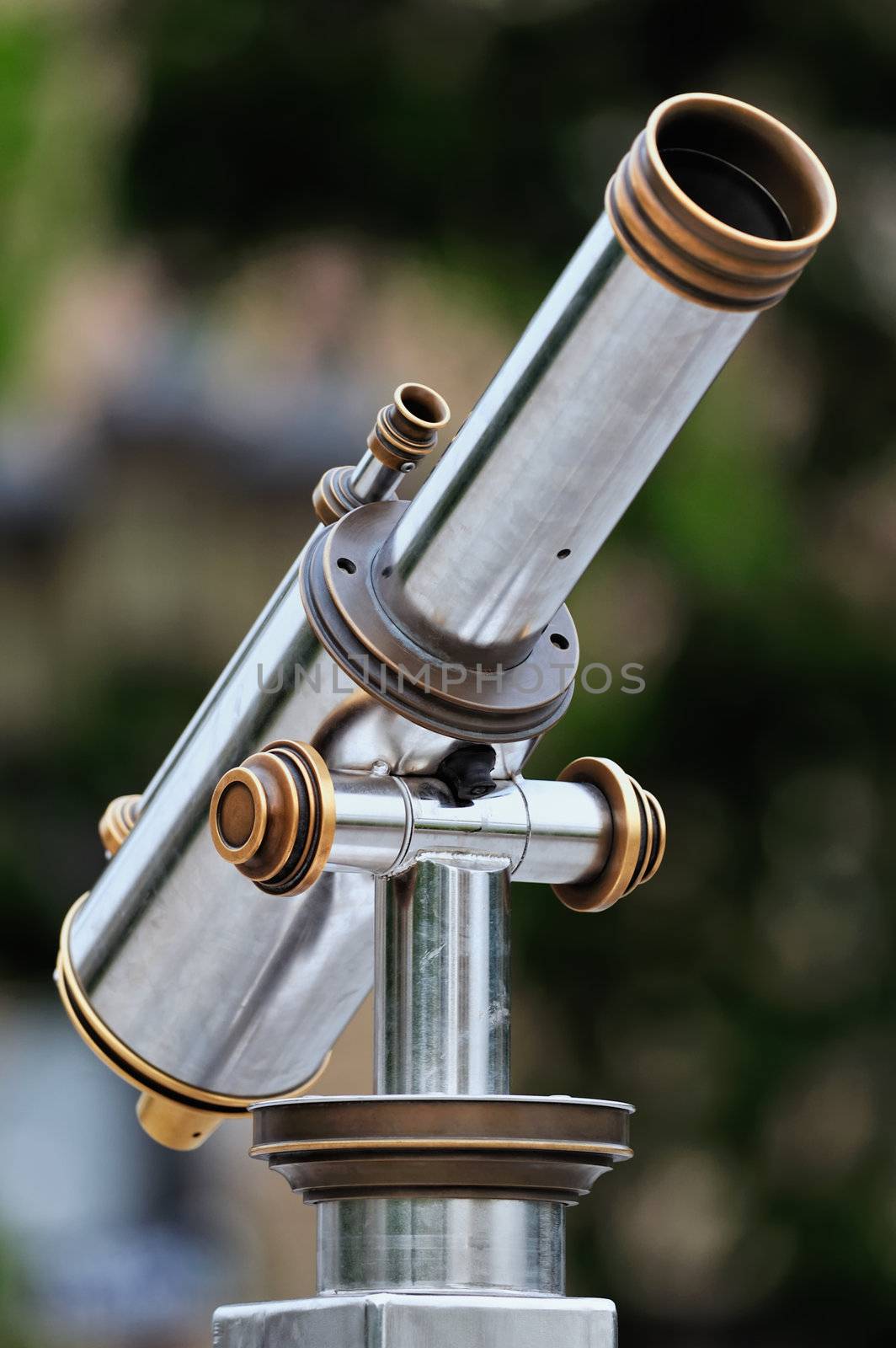 An tourist type telescope against the green trees