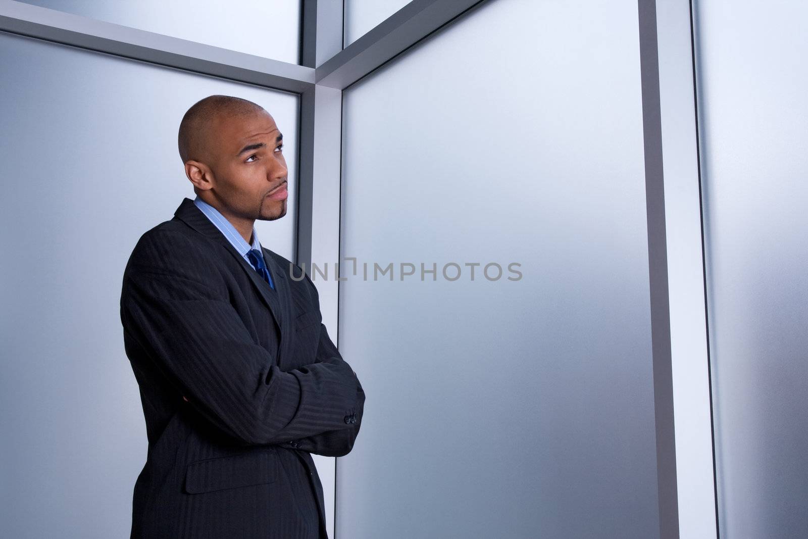 Businessman looking through the window with a worried expression.