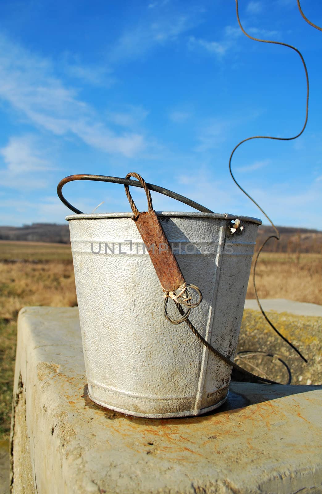 old metal bukett near a rustic traditional romanian well