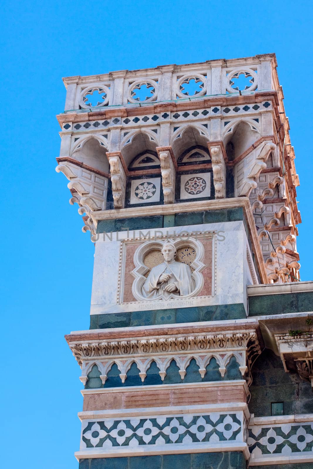 A tower with a statue on the foeef of Basilica di Santa Maria del Fiore 
