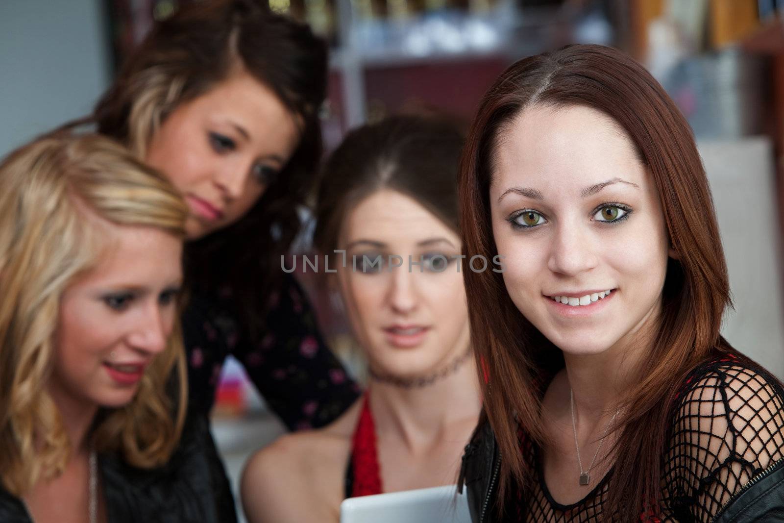 A cute young teen girl with friends in a coffee house