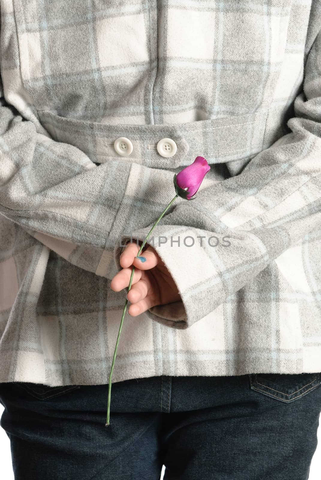 A young teenage girl is standing with a wooden rose behind her back.