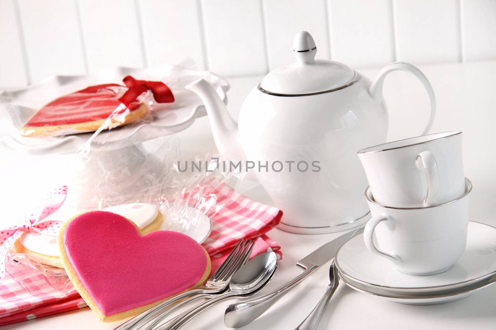 Valentine cookies with teapot and cups on kitchen counter