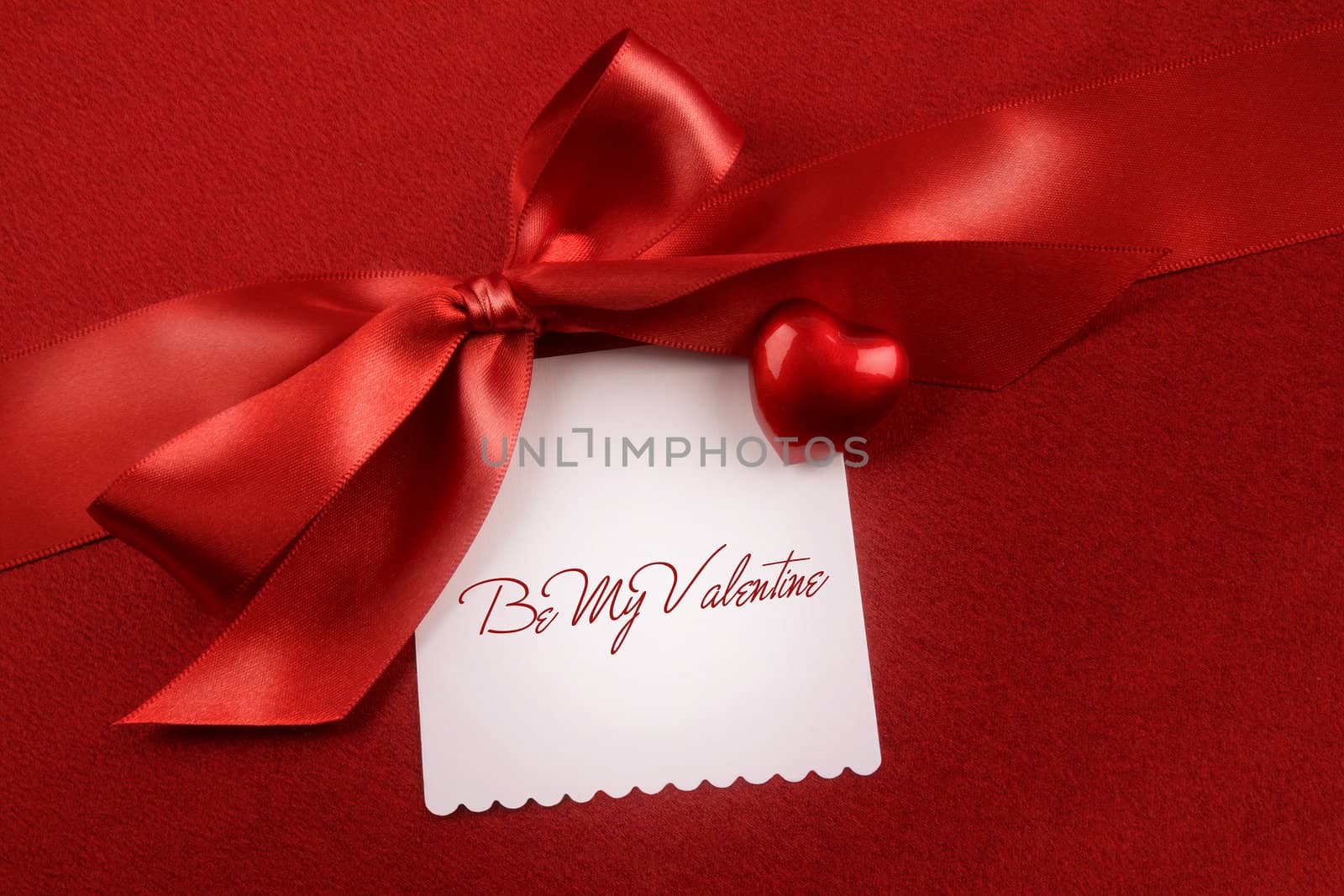 Satin bow and white card for gift on red  by Sandralise