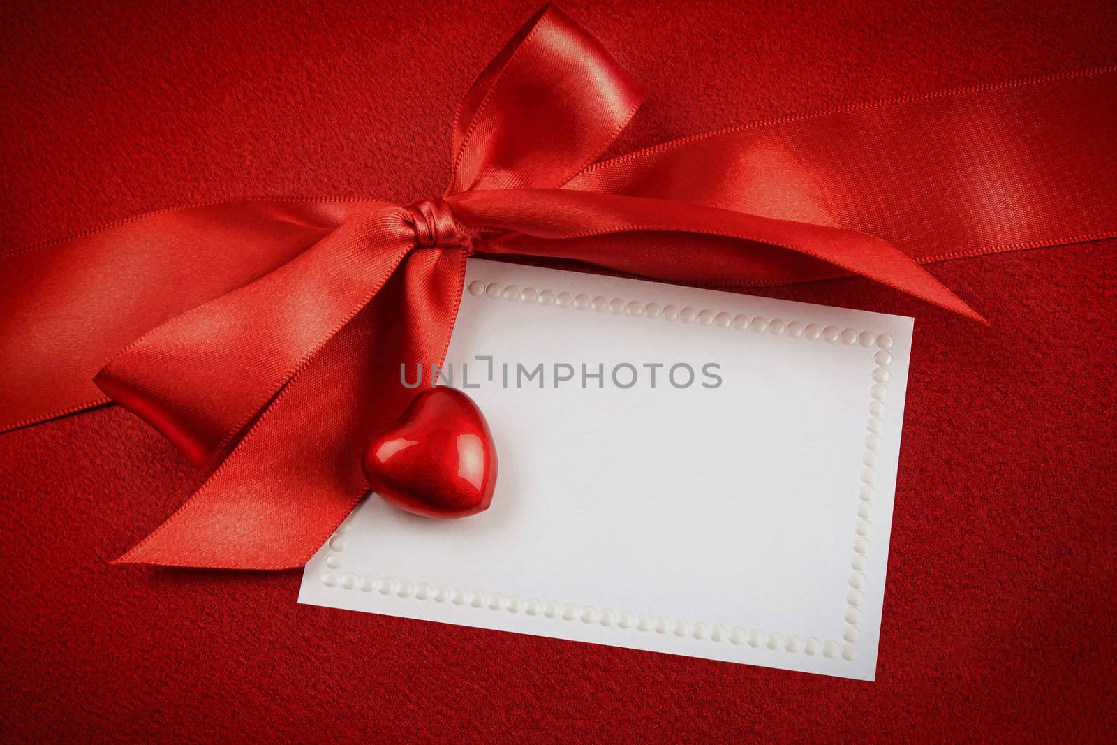 Red bow and white card for gift on  satin background by Sandralise