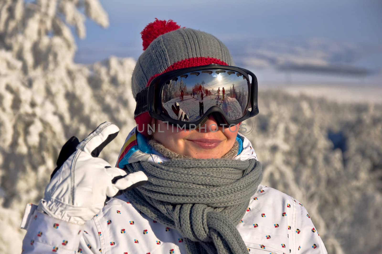 Portrait of a beautiful women snowboarders in the ski mask. Against the backdrop of snow-covered trees.