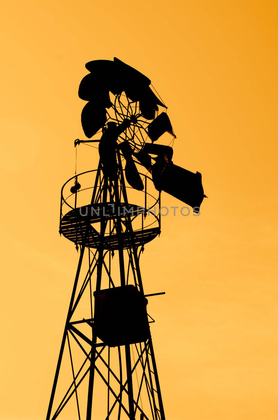 Old Farm Windmill for Pumping Water with Spinning Blades at Sunset in Aveiro, Portugal.