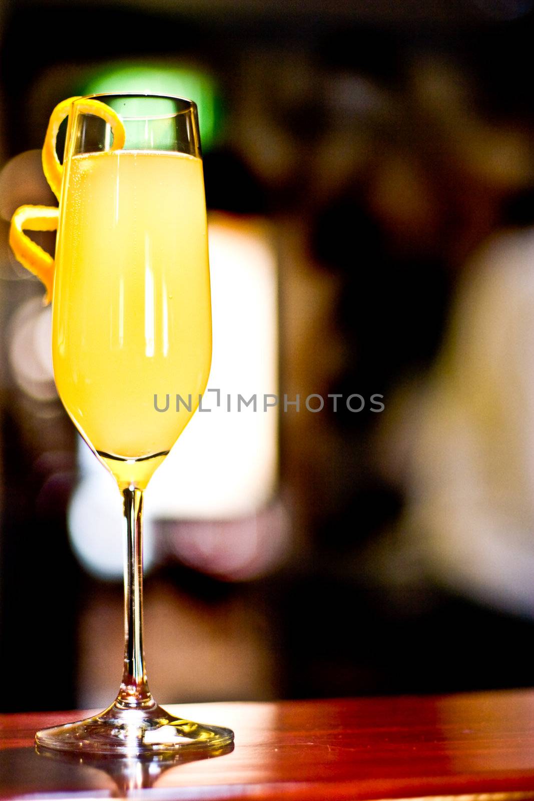 Yellow cocktail in a champaigne flute.