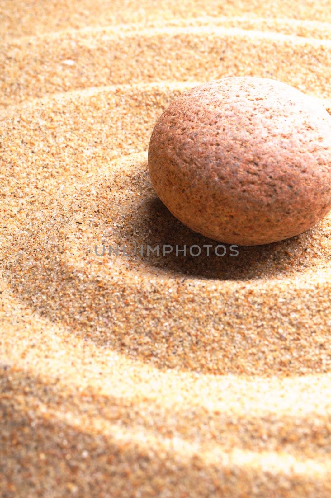 zen stone with leaf on sand showing spa concept