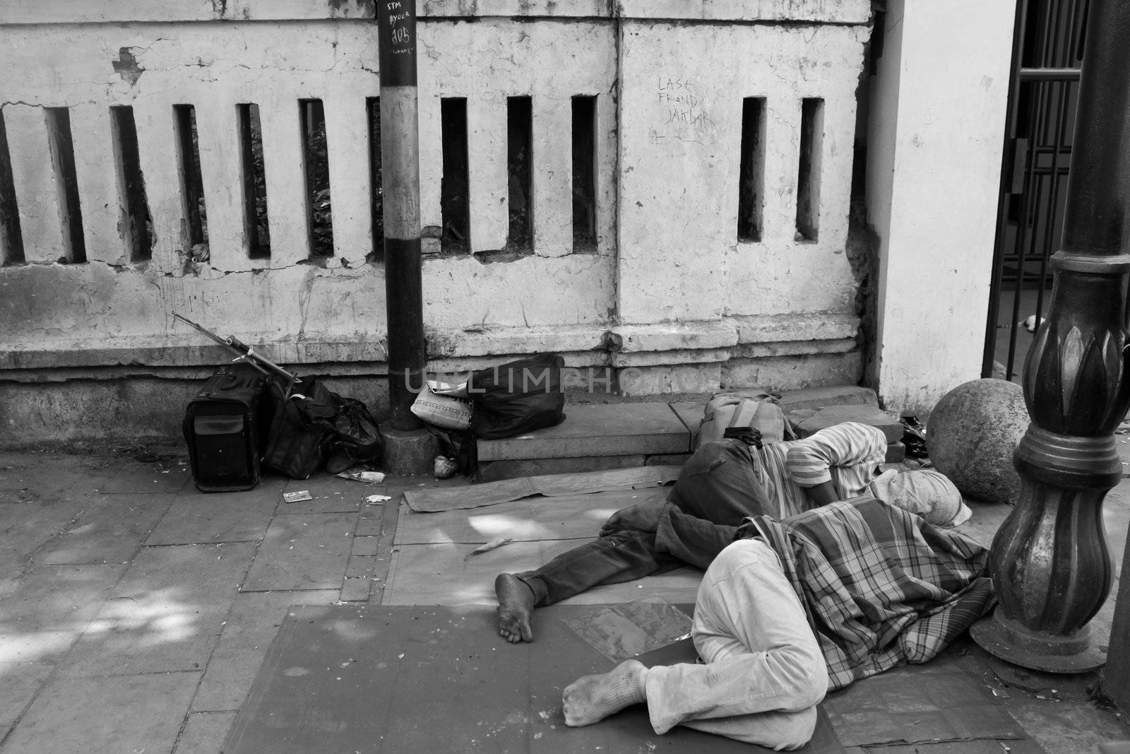 two man asleep on the roadside.