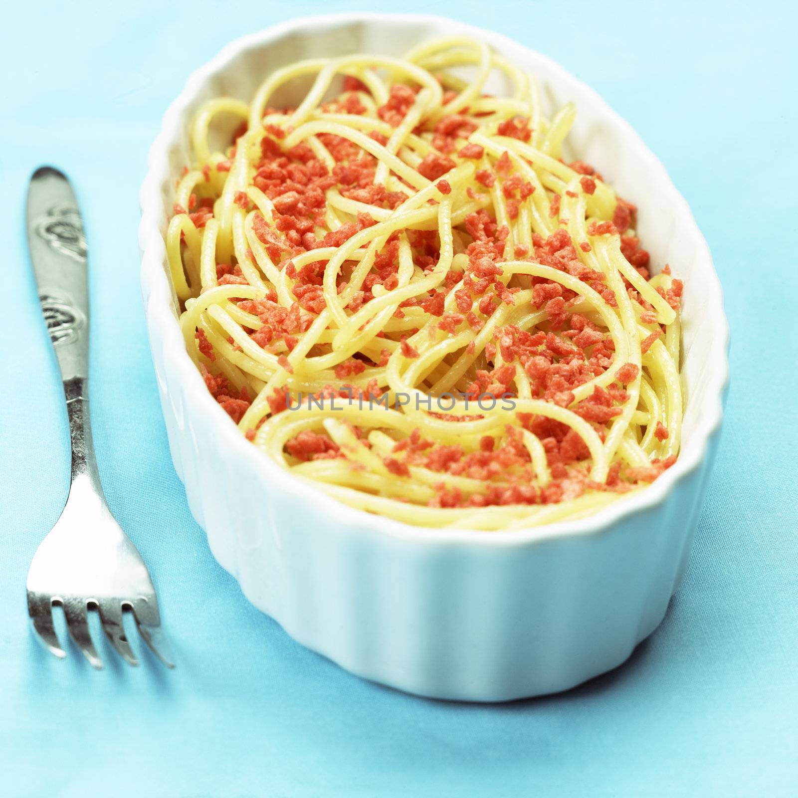 close up of a bowl of spaghetti with bacon bits