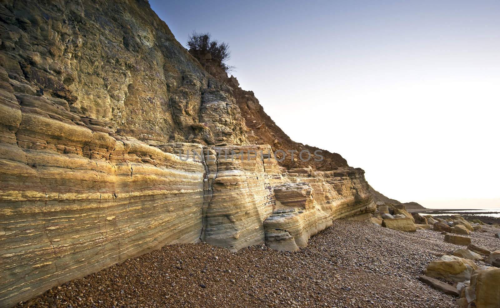 Beautiful sunrise along striated layered cliffs running along st by Veneratio