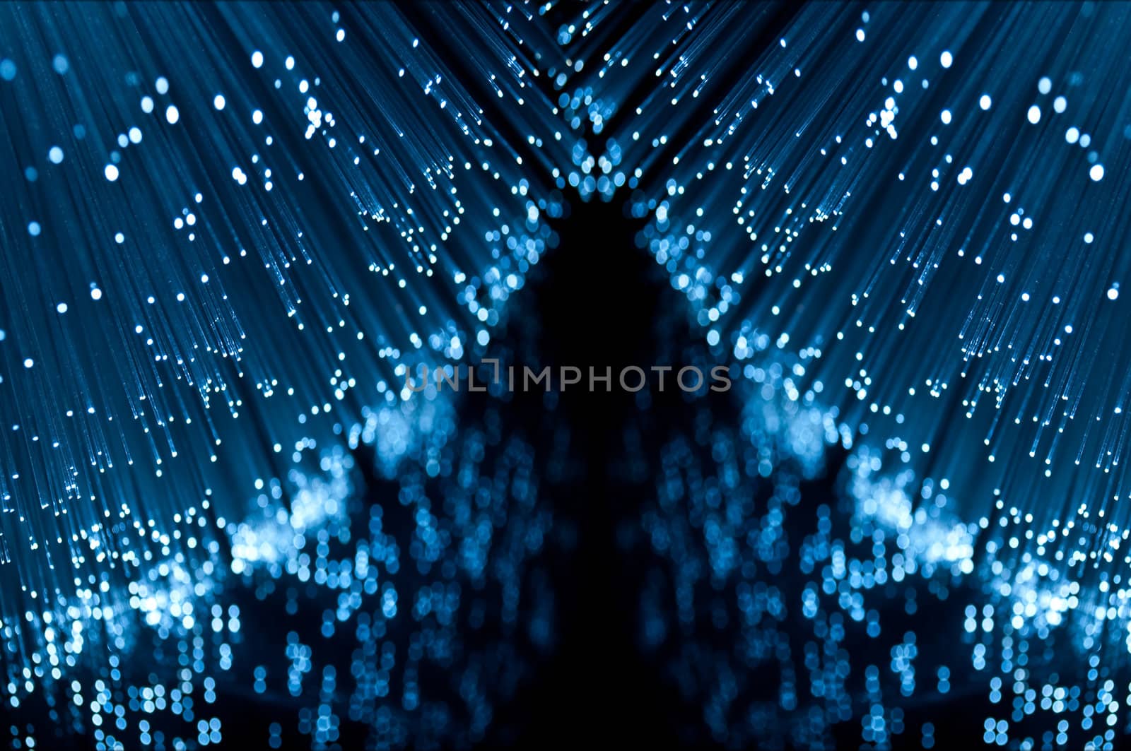 Close up and low level capturing the ends of many illuminated fibre optic light strands reflecting into the foreground.