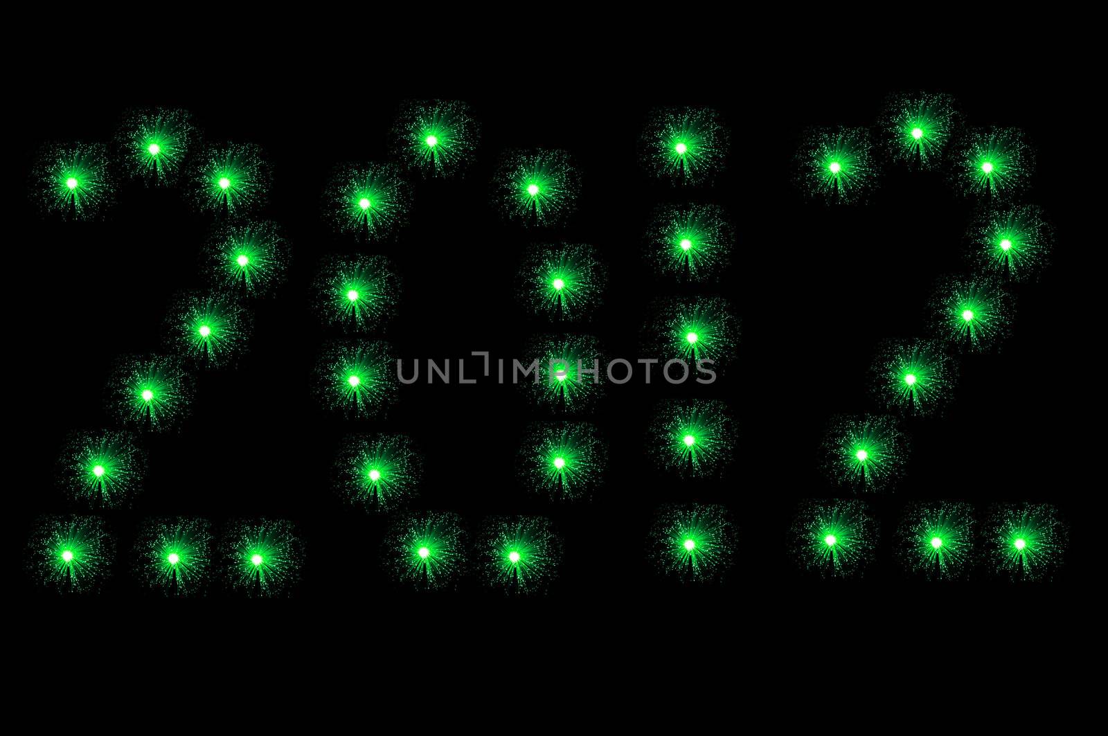 Many small illuminated green fibre optic lamps arranged on black background to spell the number 2012