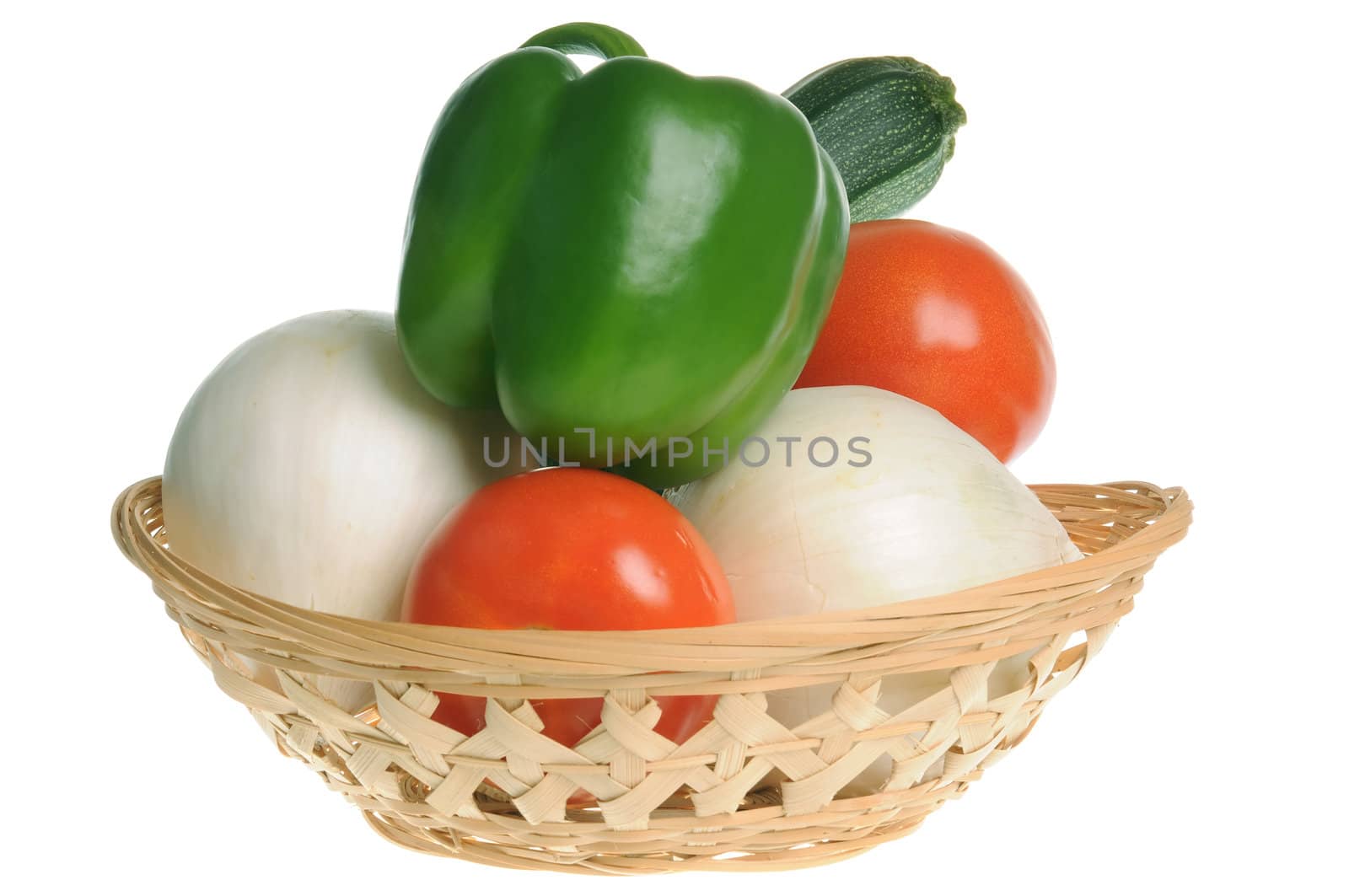 Basket with green pepper, tomatoes, onions and zucchini isolated on white background