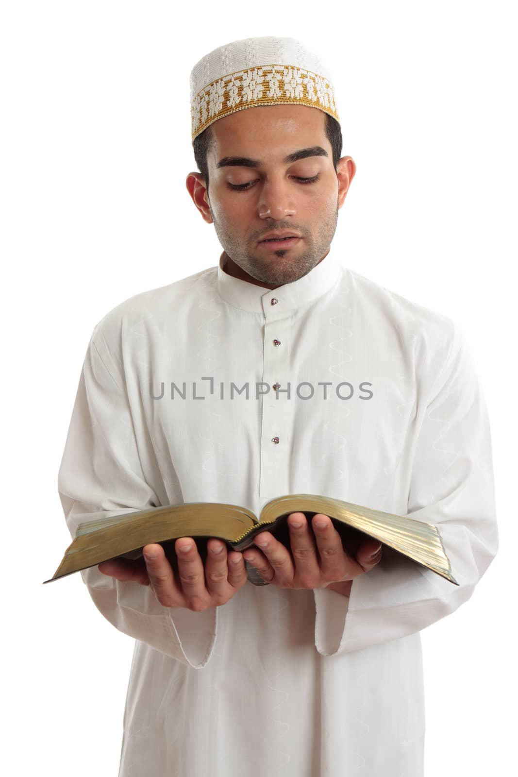 Man wearing cultural clothing is reading or studying a religious holy book.  White background.