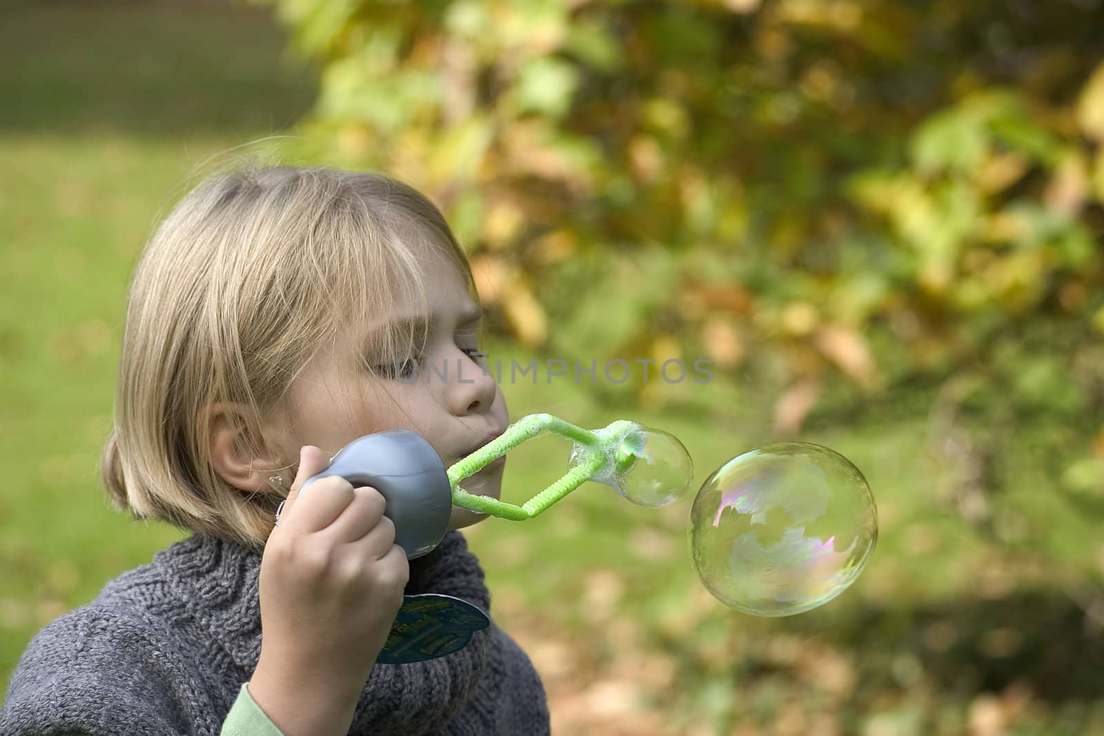 Little girl blowing soap bubbles by miradrozdowski