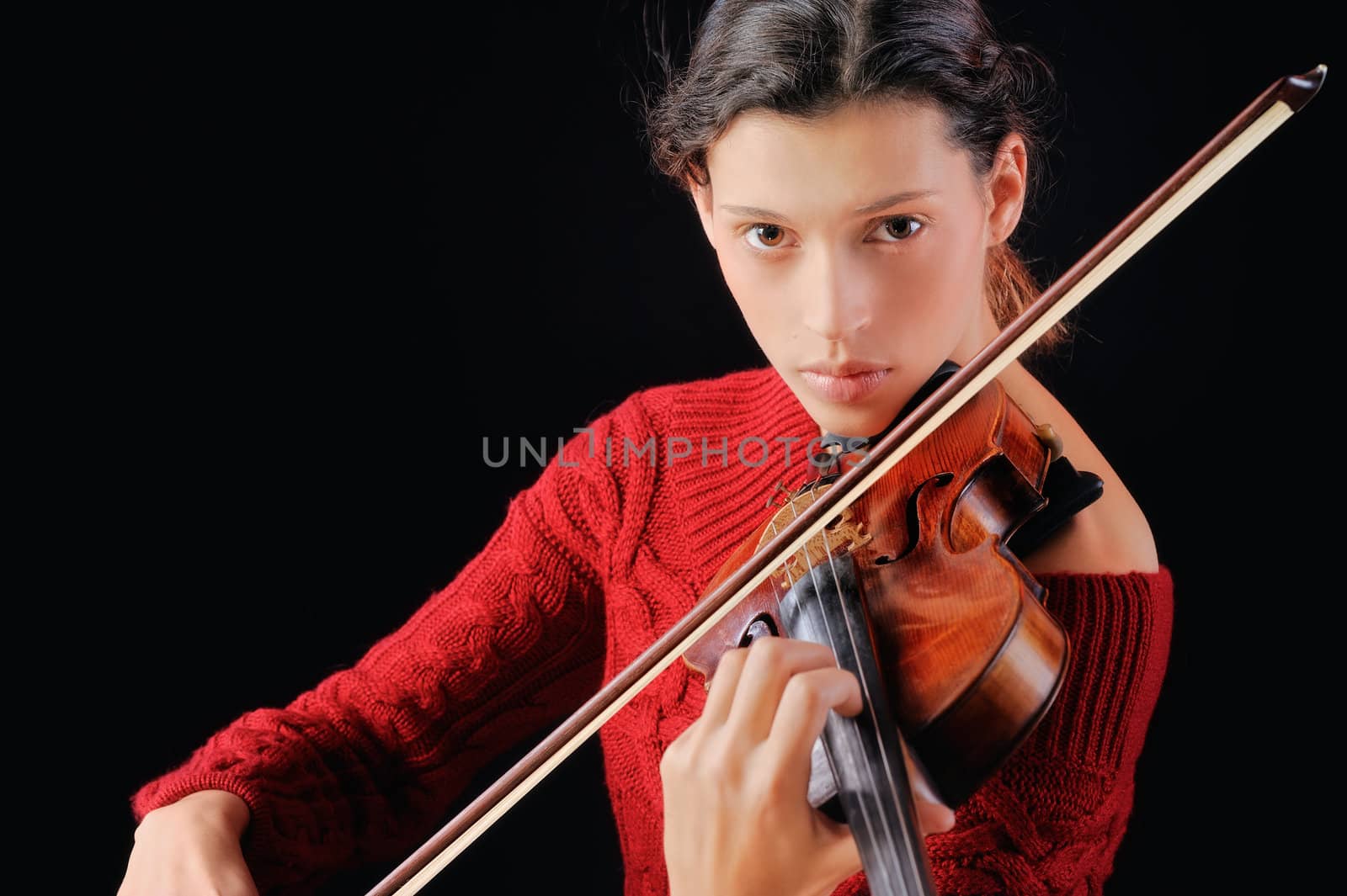 Young woman playing violin. Isolated on the black background