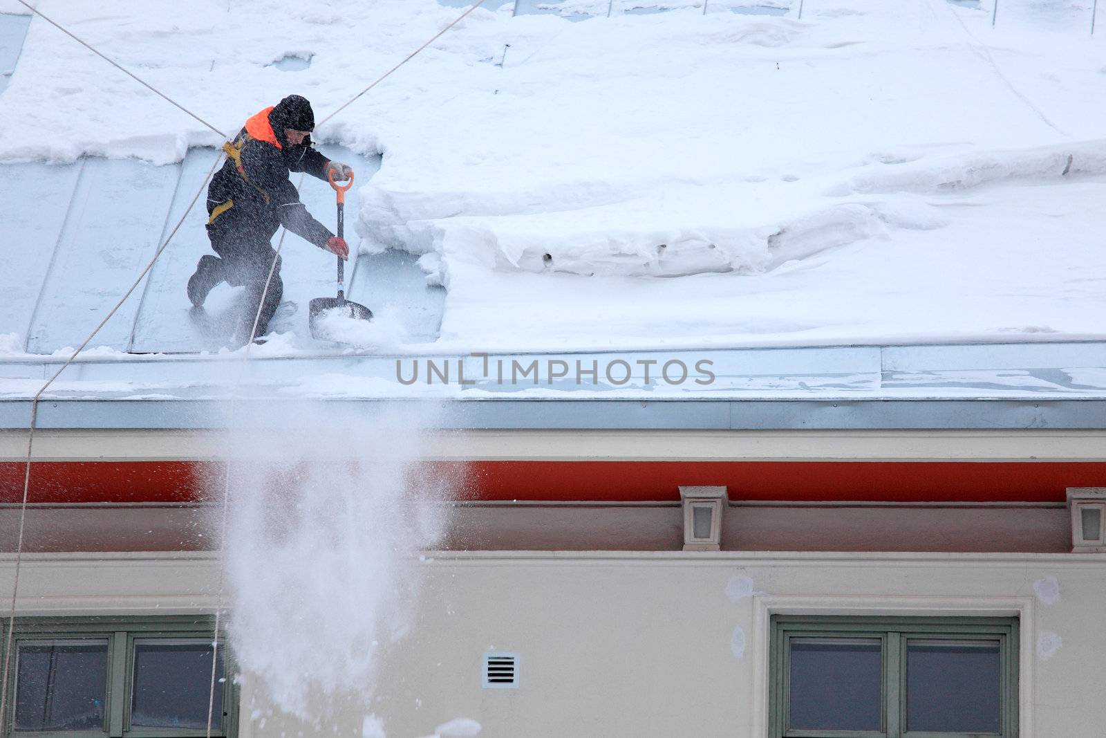 Man is de-icing a snowy Roof by PixBox