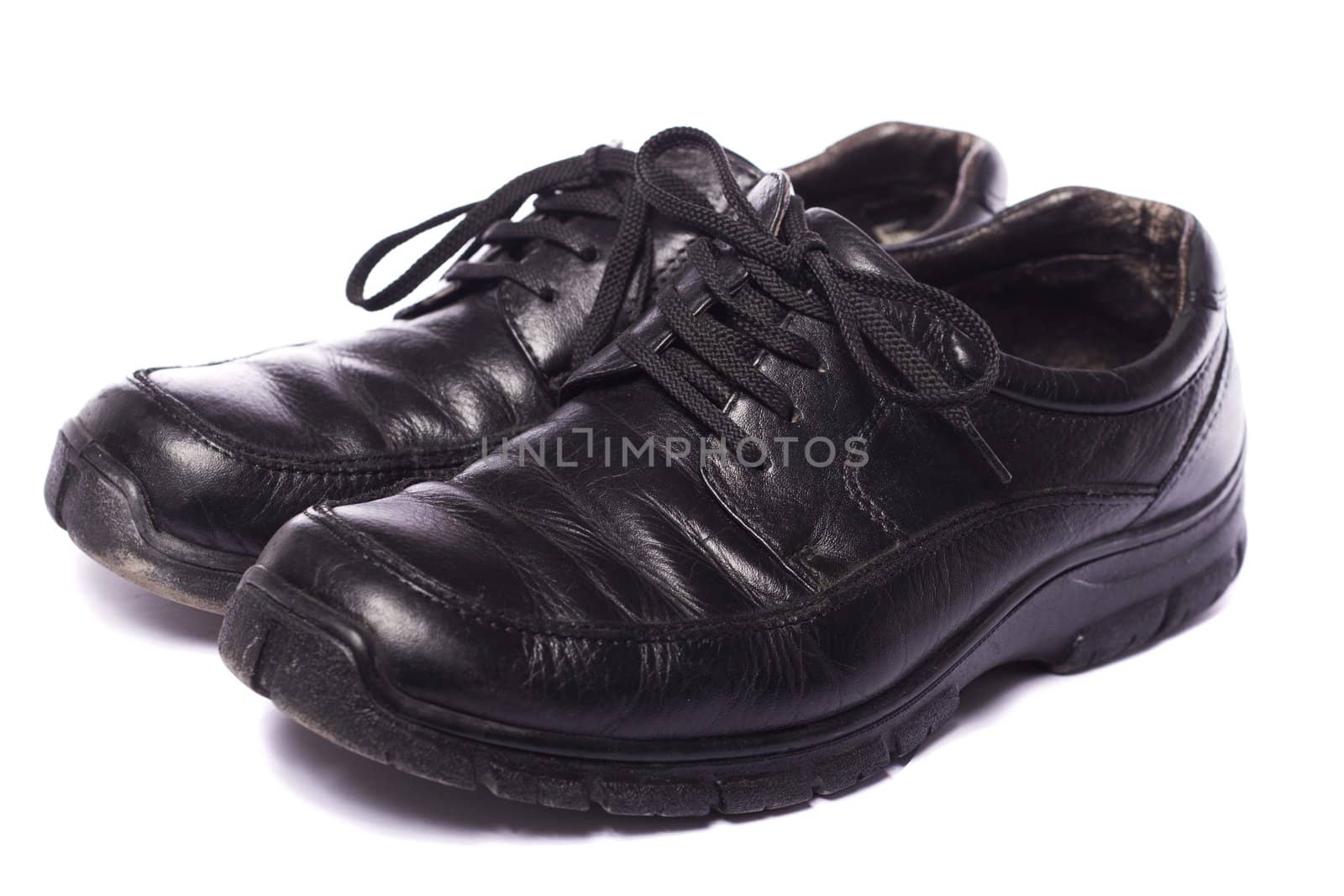 Close up view a modern pair of male black shoes isolated on a white background.