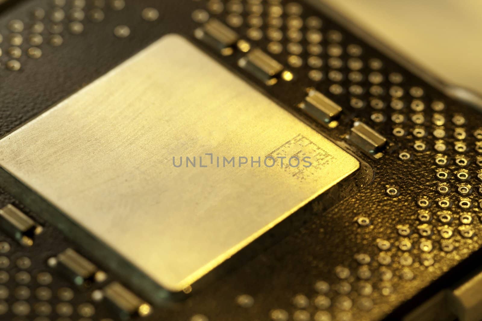 Close view detail of a computer microprocessor with a golden light.