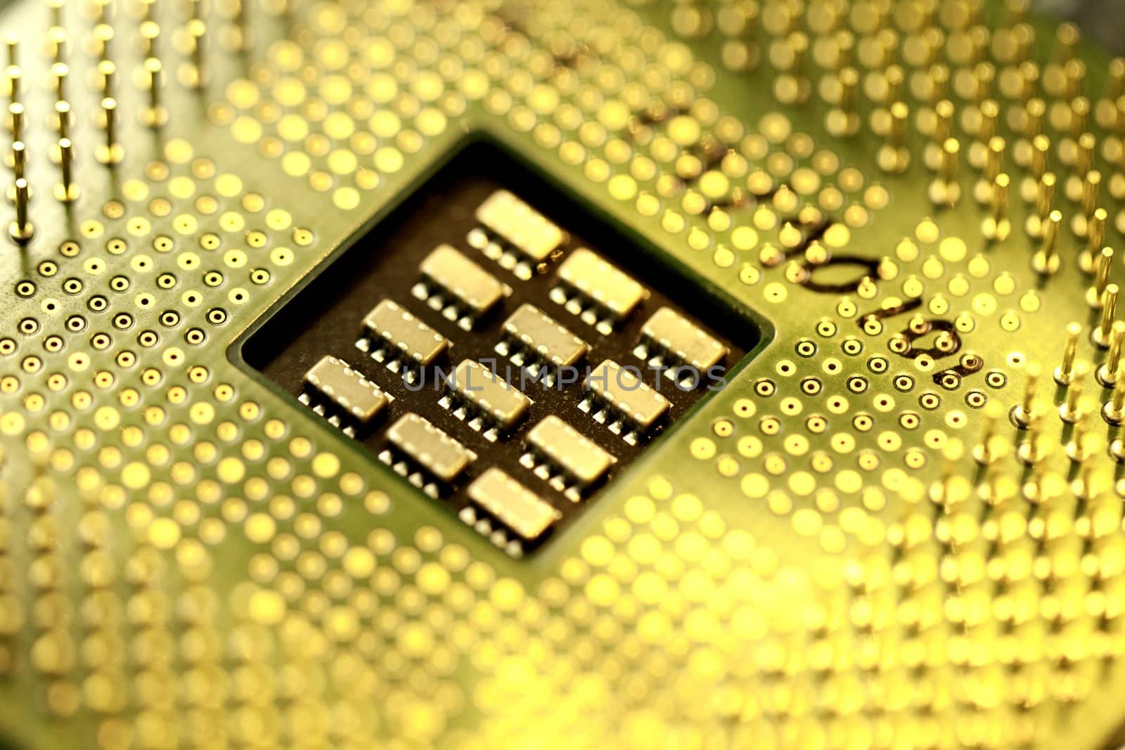 Close view detail of a computer microprocessor with a golden light.