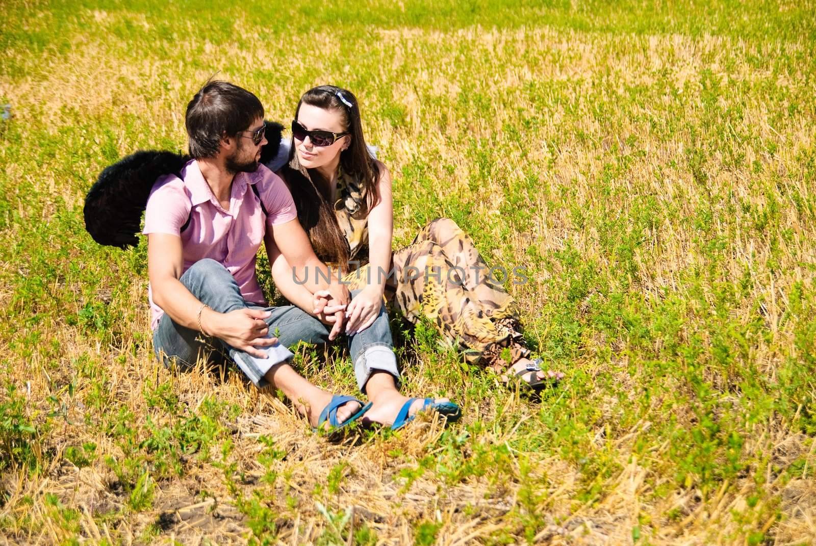Young happy couple on the field. Shoot on the nature.