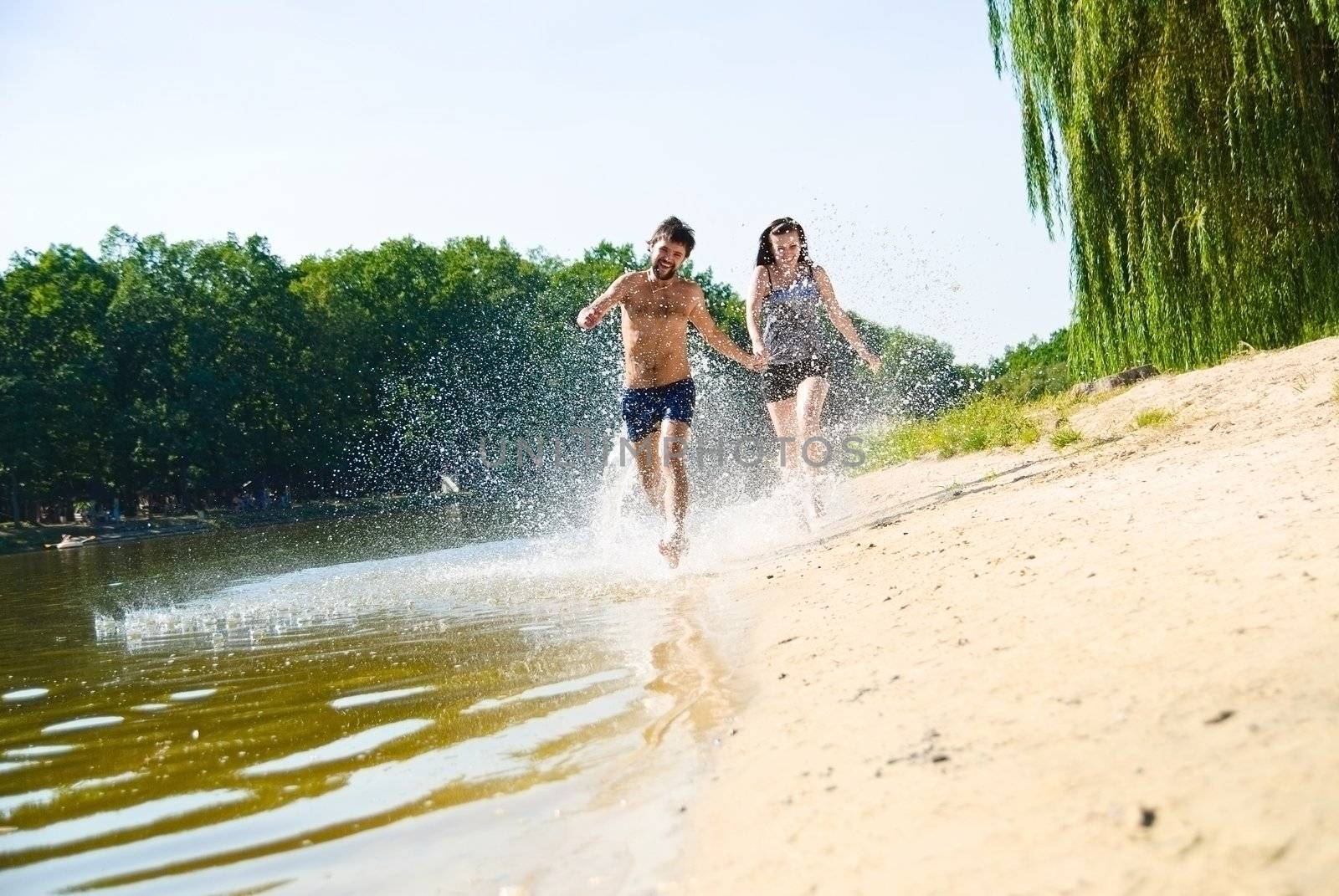 Young happy couple on the beach. Shoot on the nature.