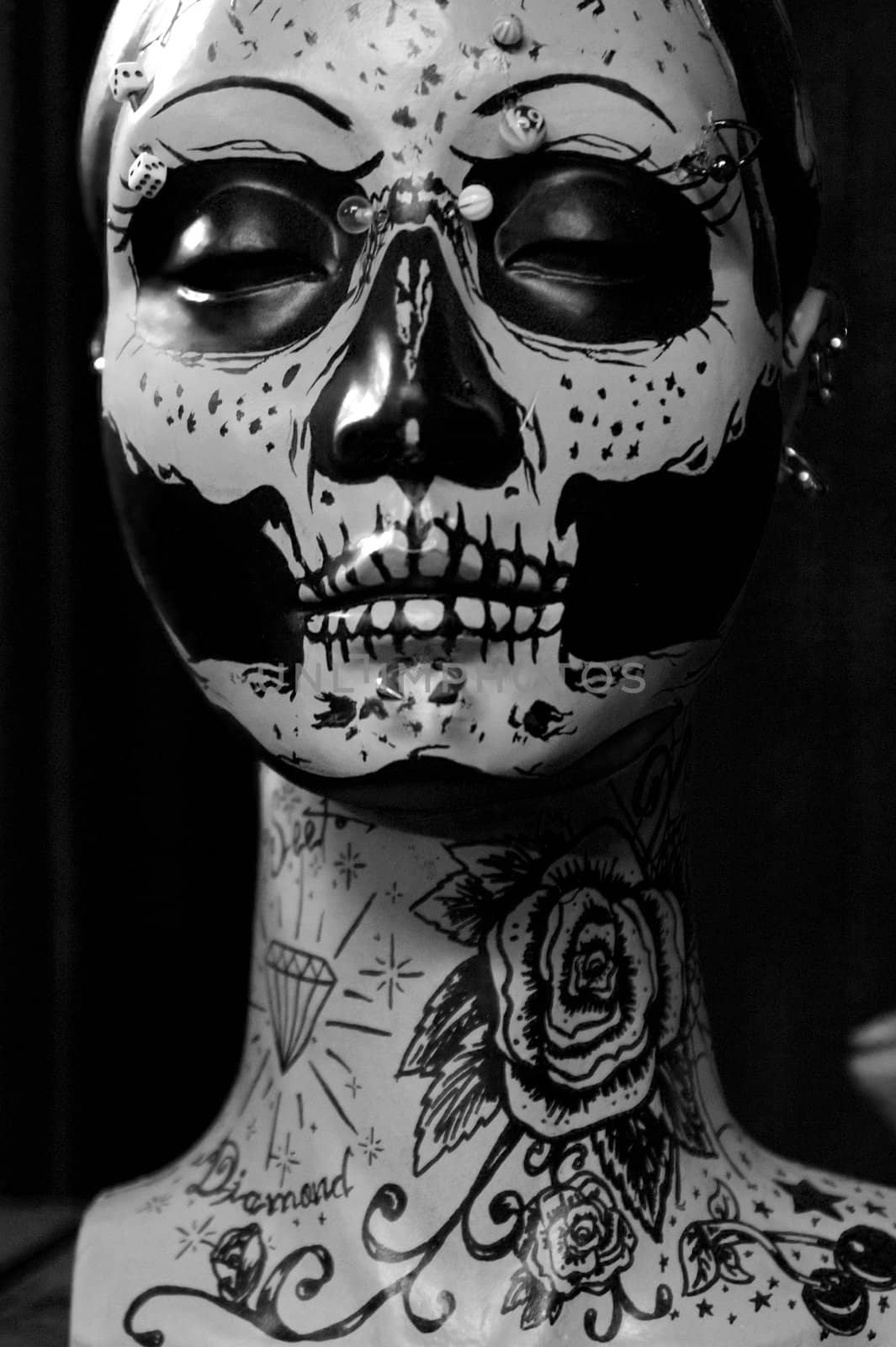 Close view of a female painted doll face with dark motifs.