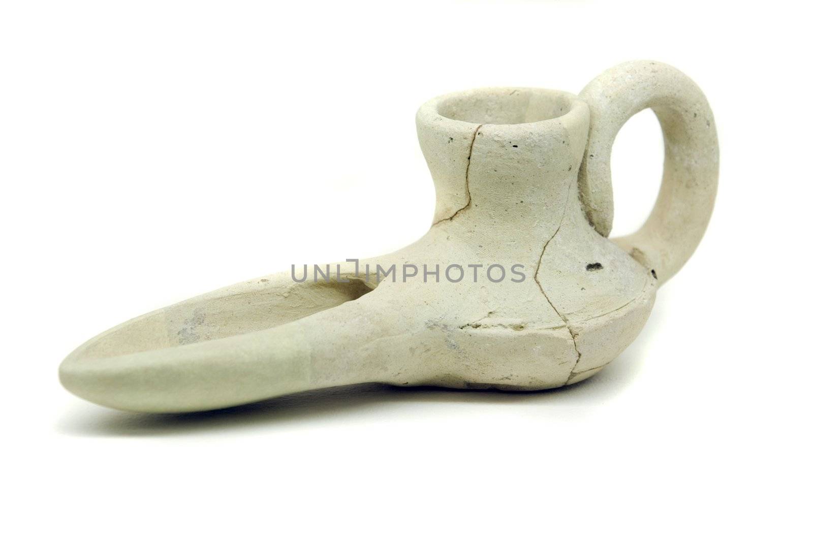 Close view of an ancient islamic oil lamp artifact on white background.