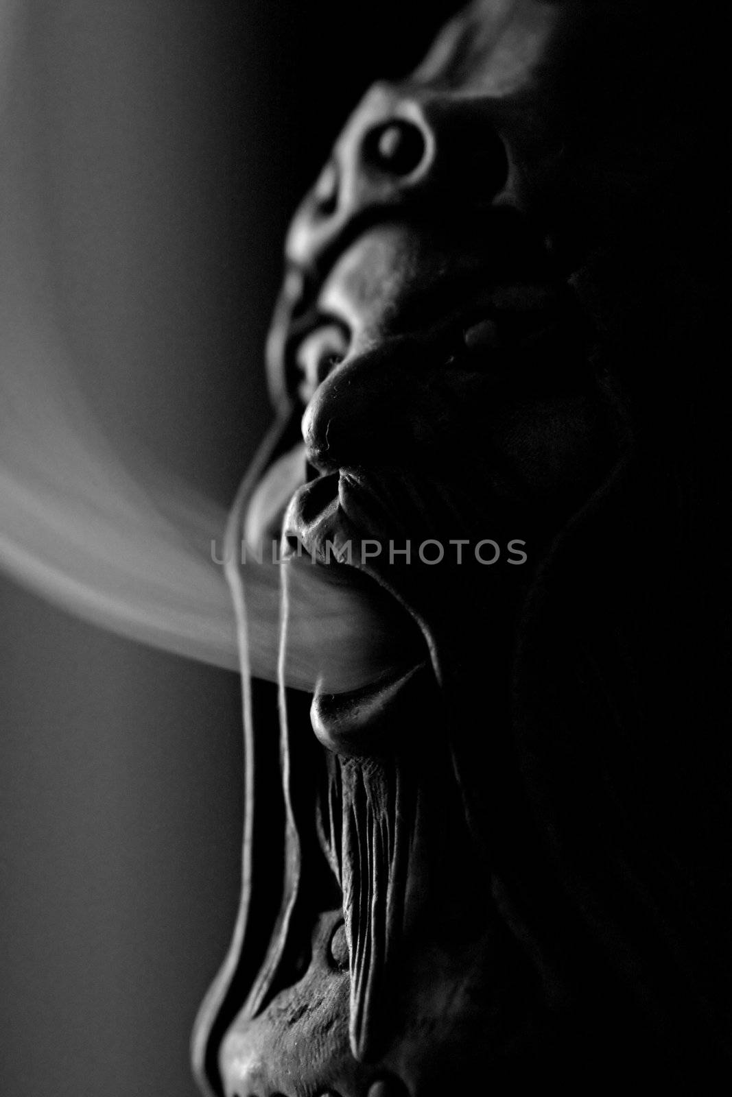 Close view of a smoking doll with smoke getting out of it's mouth.