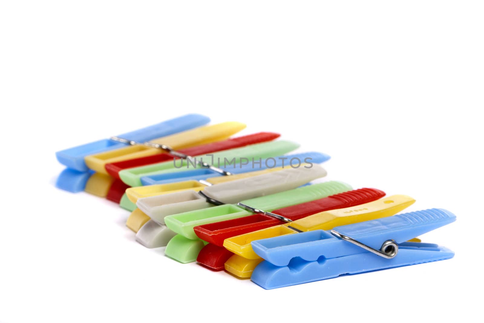 Close up view of some colorful cloth pegs isolated on a white background.