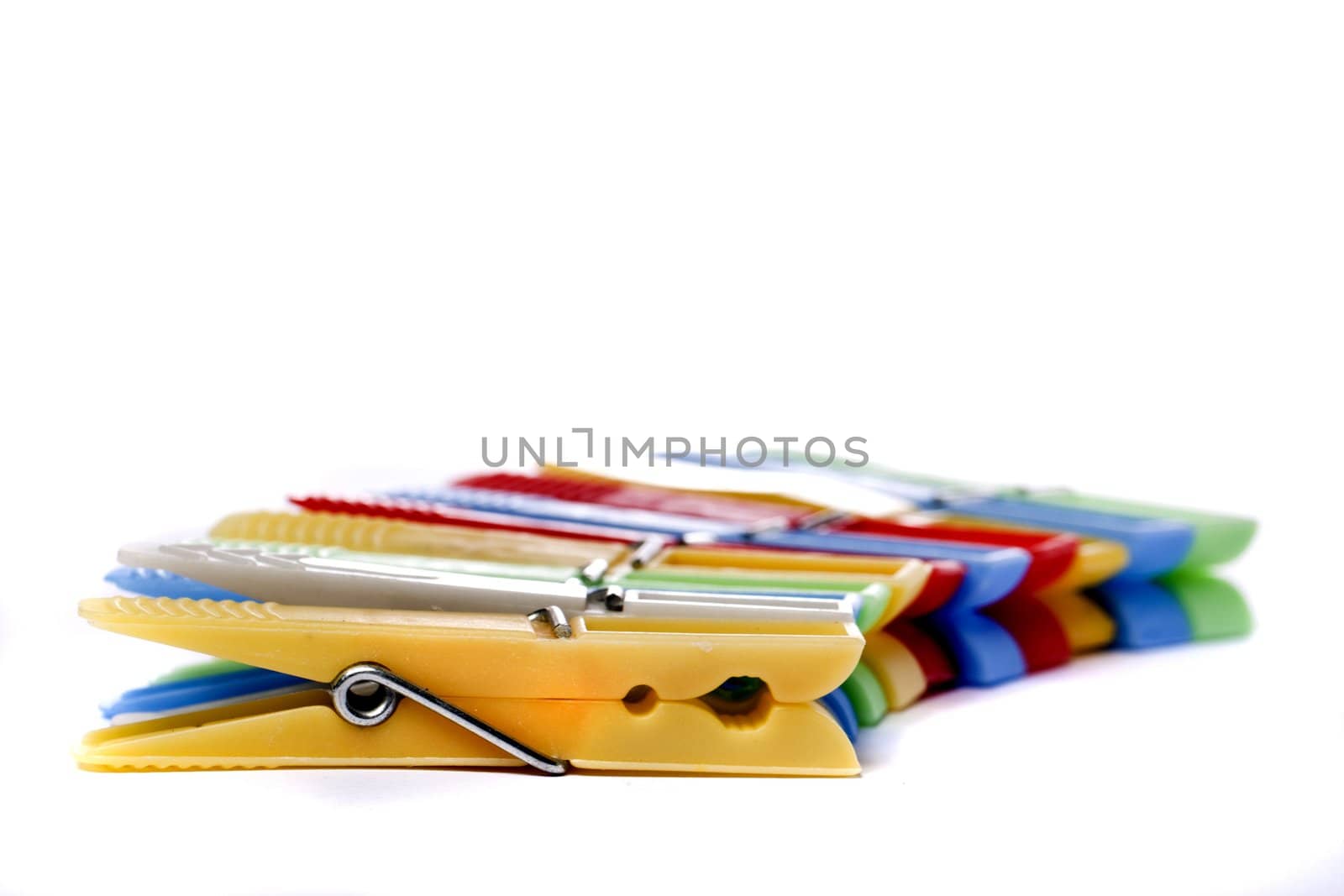Close up view of some colorful cloth pegs isolated on a white background.
