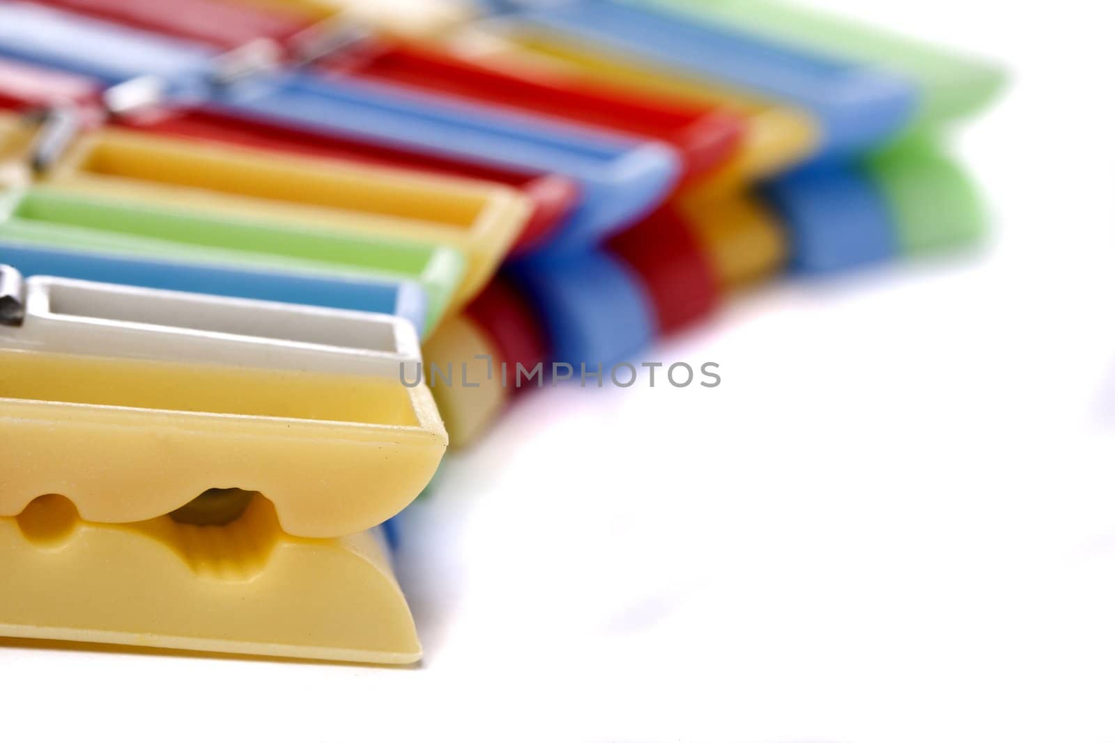 Close up view of some colorful cloth pegs isolated on a white background.