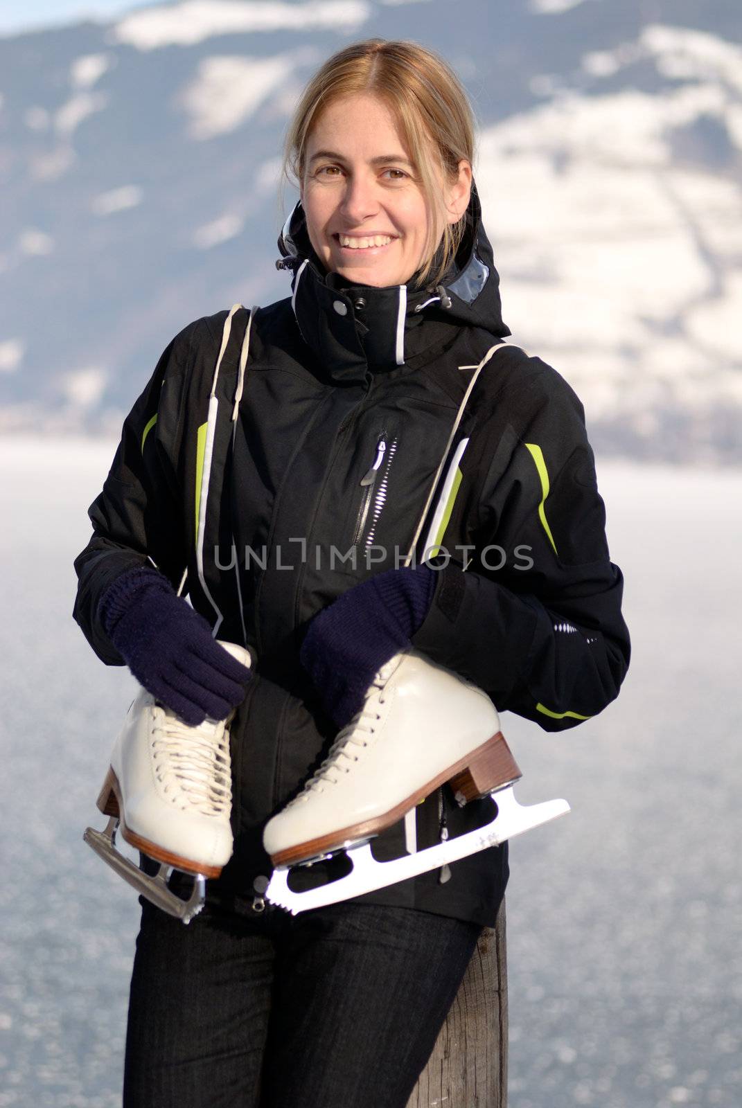 Pretty woman with ice skating schoes at frozen lake