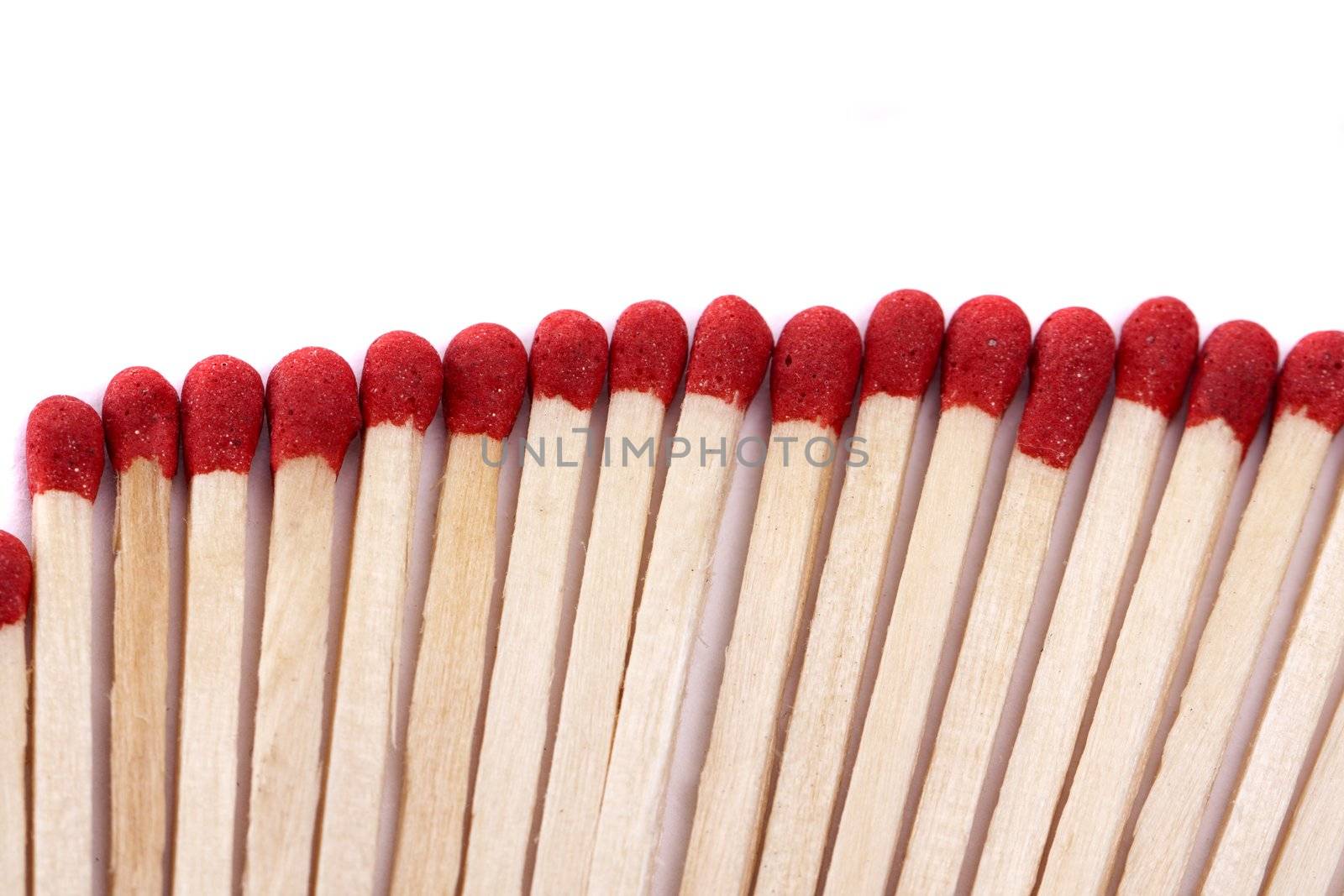 Close up view of a bunch of matches with red heads on a white background.