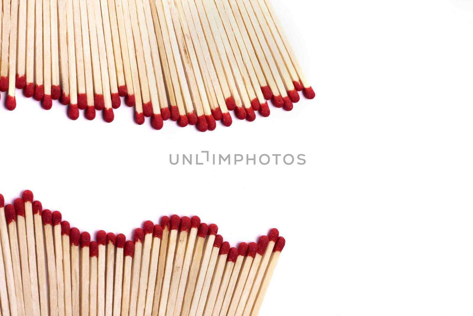 Close up view of a bunch of matches with red heads on a white background.
