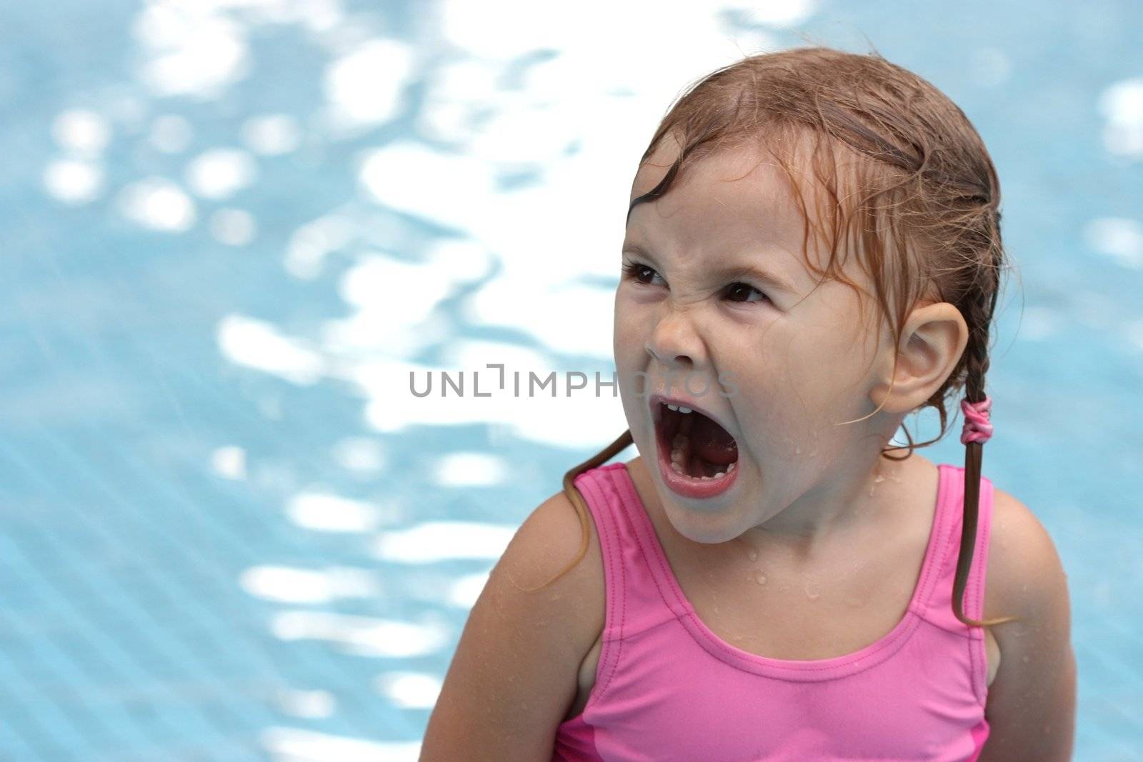 little girl in the pool opened her mouth wide