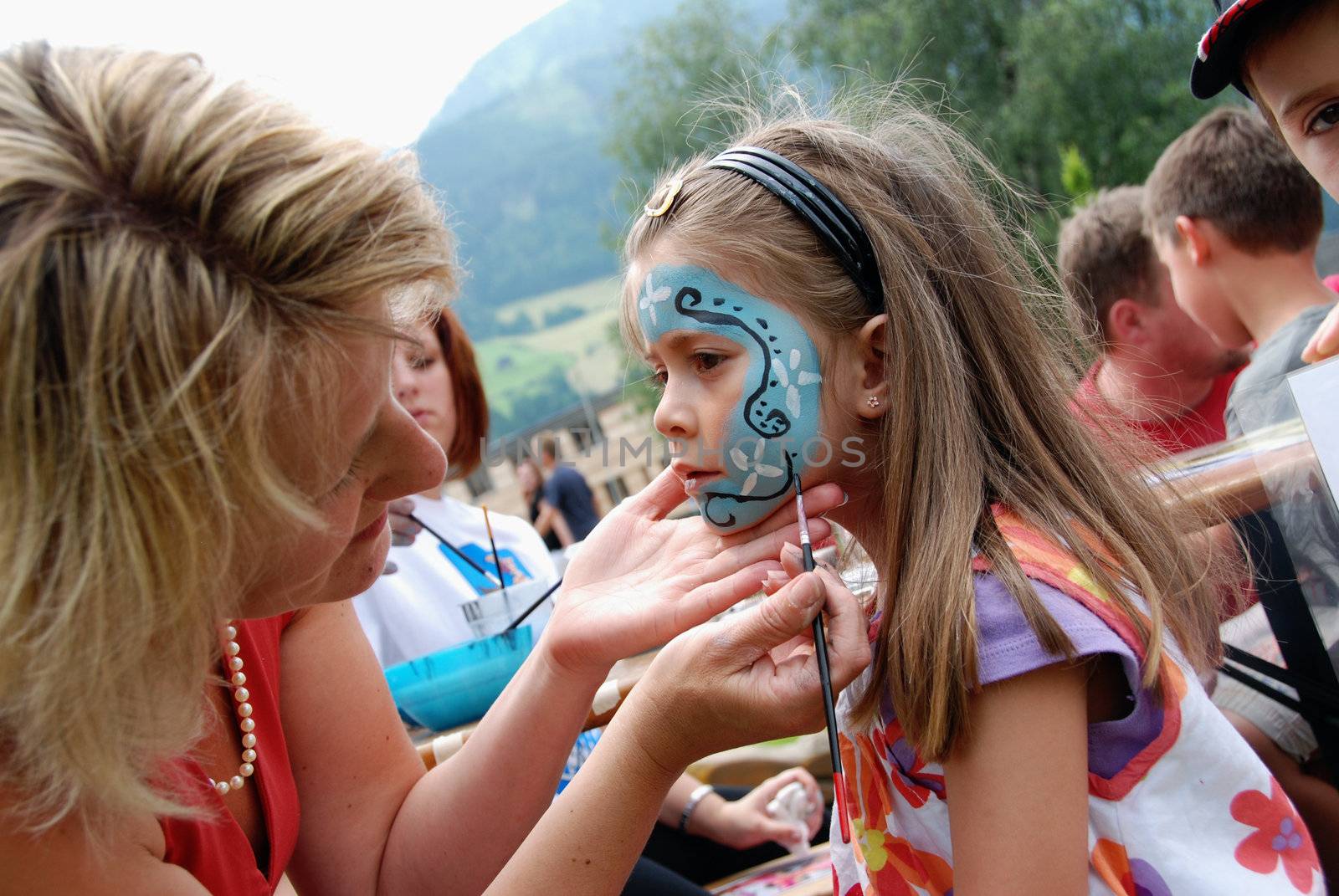 MITTERSILL, AUSTRIA - JUL 4: Children face painting at the supporting programme of the Watersports Event Erdinger Sautrogrennen on July 4, 2010 at the Zierteich in Mittersill, Austria