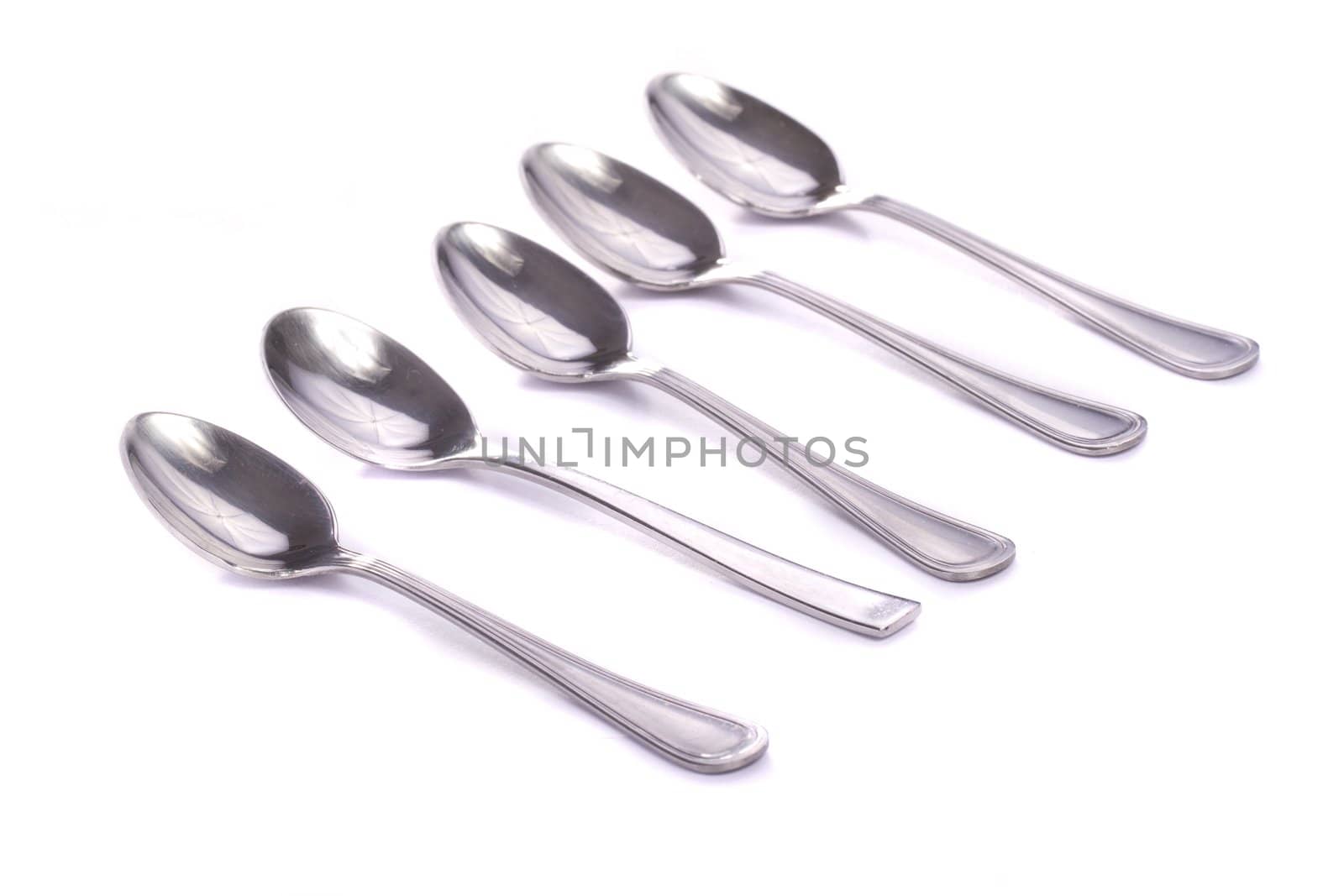 Close up view detail of some spoons isolated on a white background.
