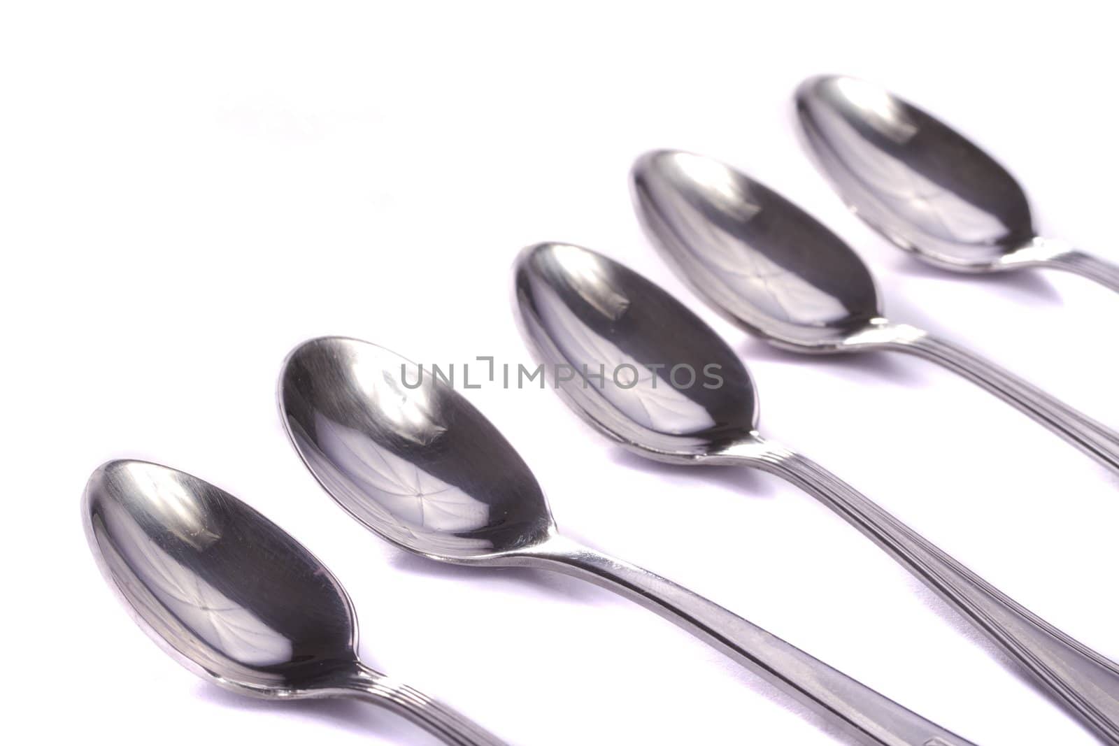 Close up view detail of some spoons isolated on a white background.