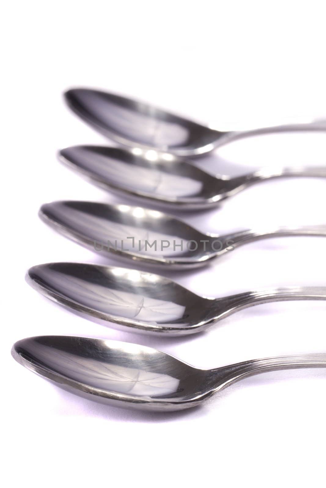 Close up view detail of some spoons isolated on a white background.