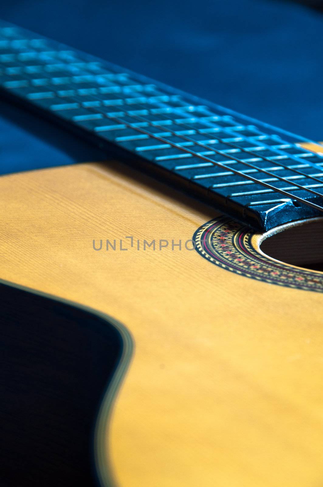 Detail shot of a beautiful acoustic guitar on dark velvet