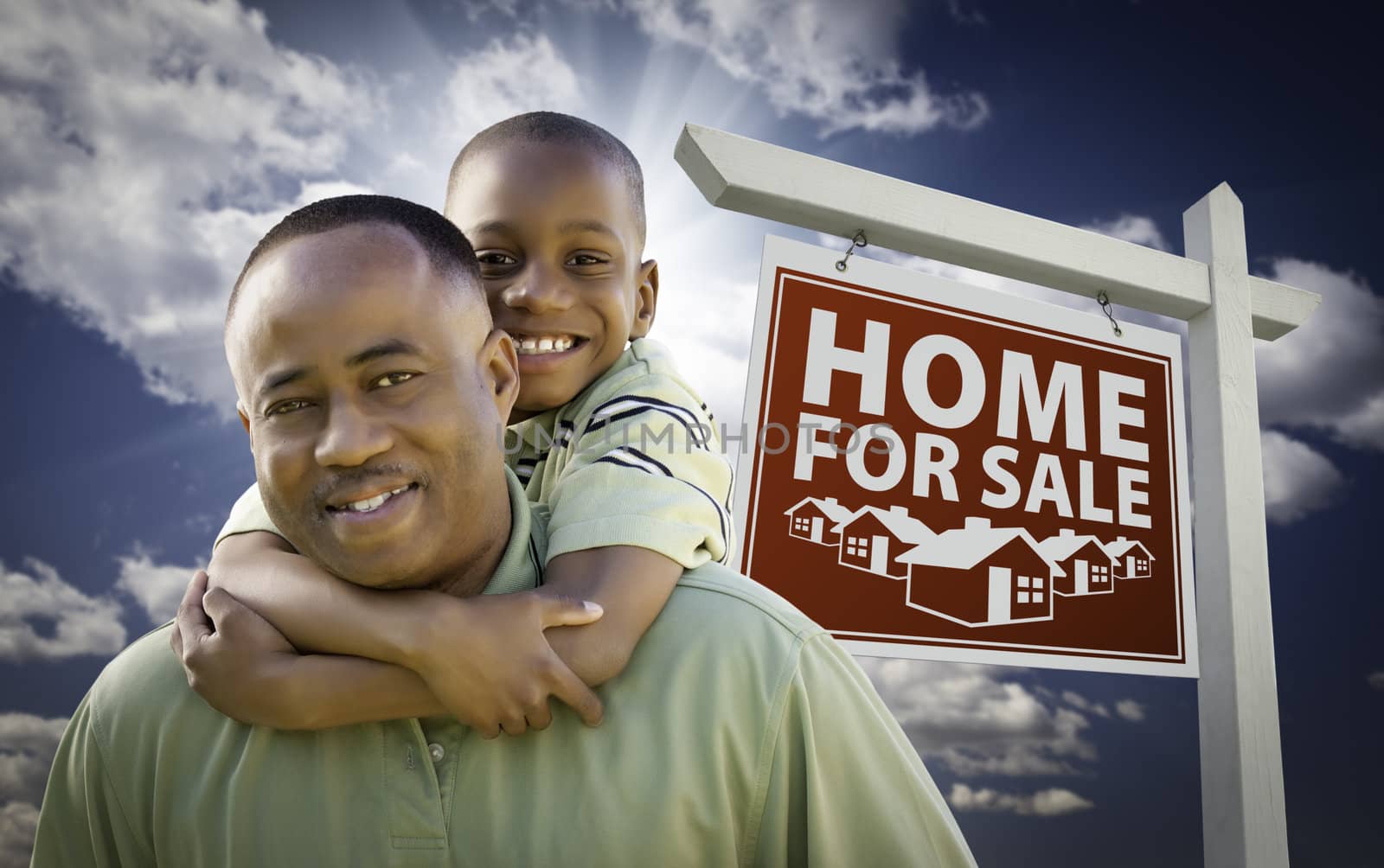 Happy African American Father with Son In Front of Home For Sale Real Estate Sign and Sky.