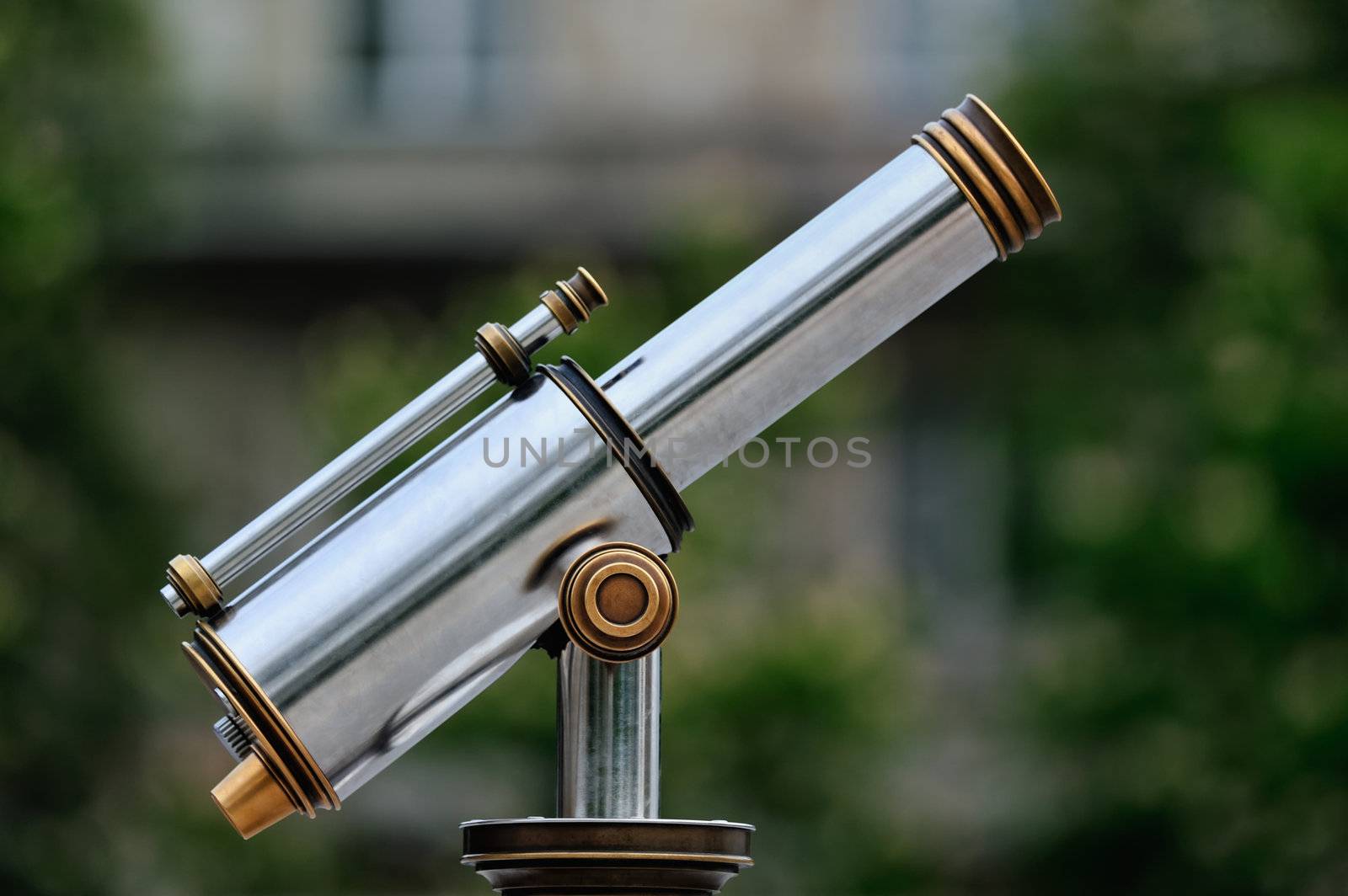 An tourist type telescope against the green trees