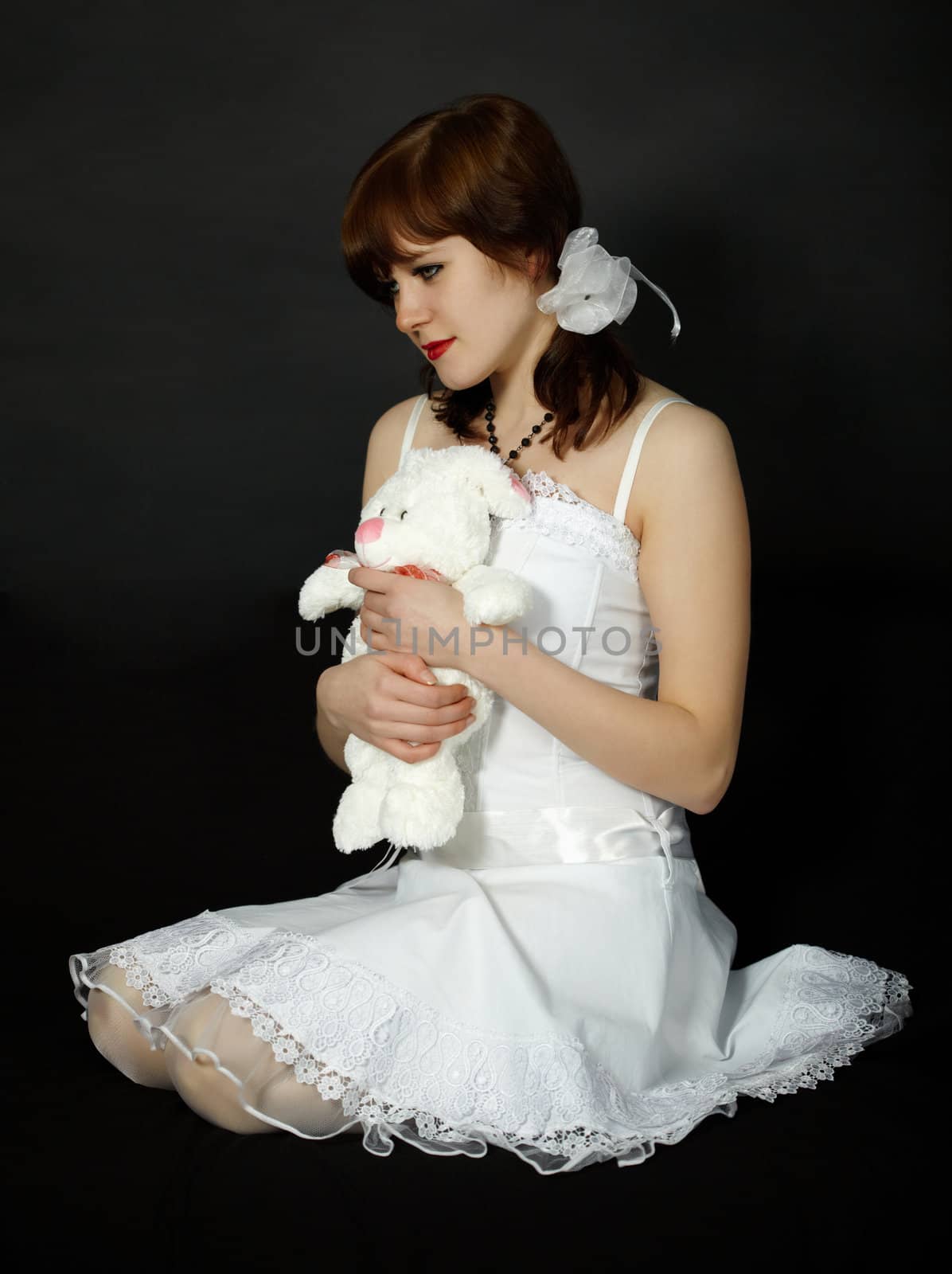 A beautiful young woman dressed in white on a black background