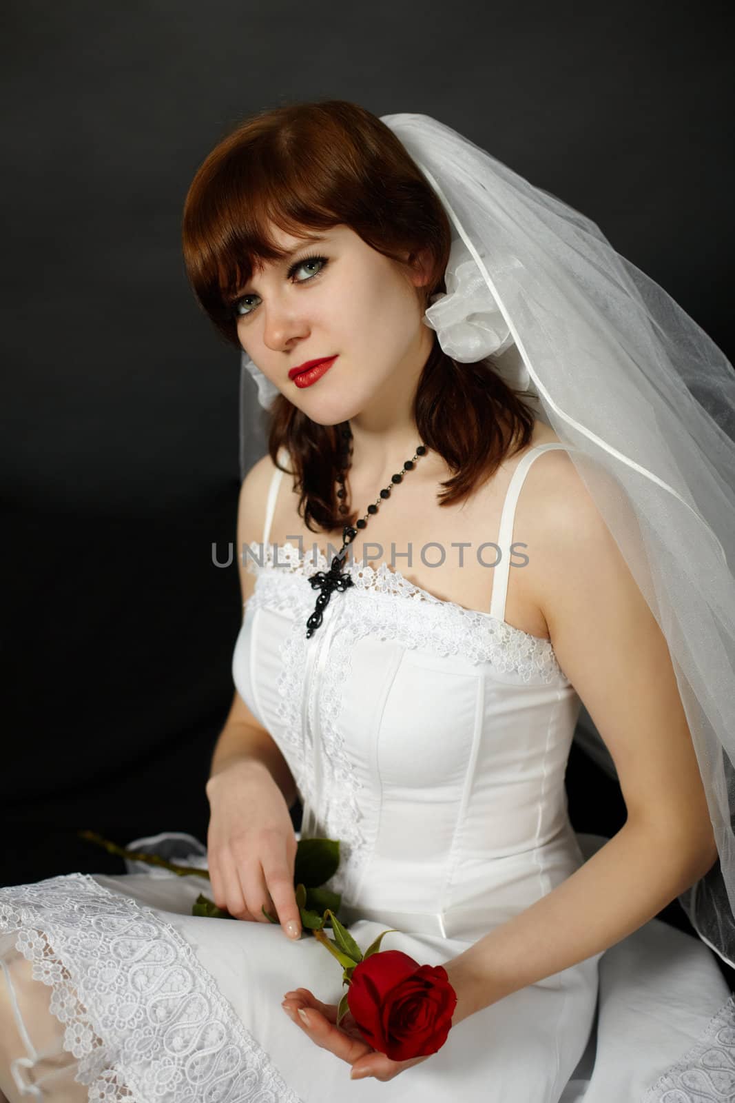 A beautiful young woman in a veil with a rose in hand